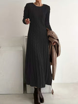 Robe maxi élégante Valenne de la marque Olyndra London, tissu fluide et coupe sophistiquée, portée par une femme.
