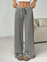 Pantalon détente Boardwalk de la marque Olyndra London, en tissu léger, porté de face avec détails de couture.