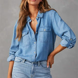 Top en denim bleu clair à boutons de la marque Olyndra London, élégant et décontracté, visible avec col et manches longues.