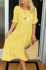 Robe midi élégante LIVIA de Olyndra London avec pois jaunes et design fluide, vue de face sur fond neutre.