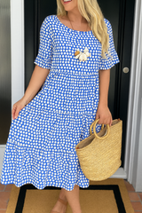 Robe midi élégante LIVIA de Olyndra London à pois bleus, coupe fluide et style sophistiqué, portée avec accessoires.