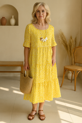Robe midi élégante jaune LIVIA de Olyndra London, tissu fluide et coupe sophistiquée, portée avec accessoires.
