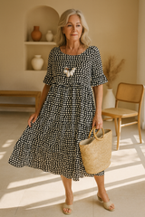 Robe midi élégante LIVIA de Olyndra London, tissu fluide avec décolleté en V, portée pour une allure sophistiquée.