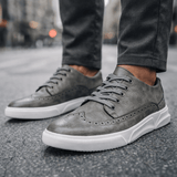 Chaussures sneakers Caldwell style brogue d'Olyndra London, en cuir noir avec détails perforés et semelle en caoutchouc blanche.