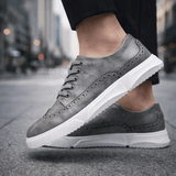 Chaussures brogue Caldwell de Olyndra London, sneakers style élégants en cuir brun avec détails perforés.