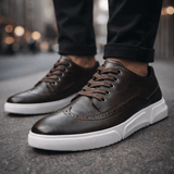 Chaussures sneakers Caldwell style brogue de la marque Olyndra London, détails en cuir marron clair et semelle blanche.
