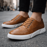 Chaussures sneakers Caldwell style brogue Olyndra London en cuir marron avec motifs brogue, vue de face.