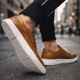Chaussures Caldwell style brogue de Olyndra London, sneakers en cuir avec détails perforés et semelle blanche.