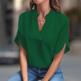 Top classique Francesca à col en V d'Olyndra London porté par Elena avec un look vert élégant.