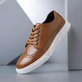 Chaussures Olyndra London Caldwell Sneakers style brogue en cuir marron avec lacets et semelle en caoutchouc.