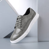 Chaussures Olyndra London Caldwell style brogue en cuir noir, détails classiques et semelle en caoutchouc.
