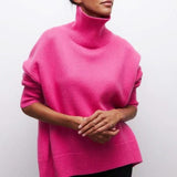 Pull-over oversize ARIA de Olyndra London avec col roulé, en laine douce, porté de profil sur une mannequin.