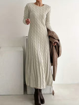 Robe longue élégante VALENNE de Olyndra London, en tissu fluide avec décolleté en V et manches longues, portée en soirée.