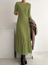 Robe longue élégante Valenne de la marque Olyndra London, tissu fluide et finition sophistiquée, portée avec accessoires.