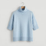 Pull oversized ARIA de Olyndra London, col roulé en laine douce, couleur gris clair, porté avec manches longues.