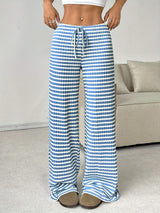 Pantalon détente BOARDWALK de la marque Olyndra London, confortable, en tissu léger, porté en mode décontracté.